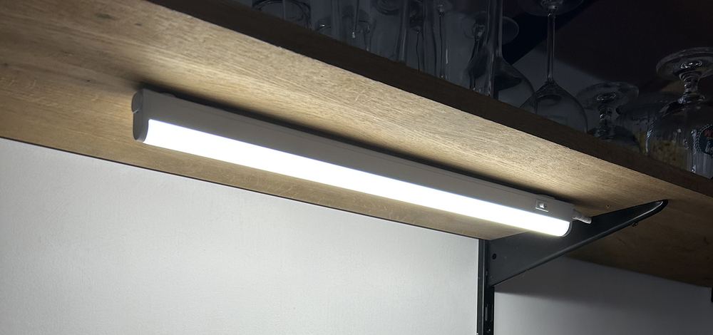 Réglette LED blanche fixée sous une étagère pour éclairer le plan de travail de la cuisine
